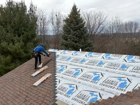 Homes Roofing crew installing new shingles over fresh underlayment
