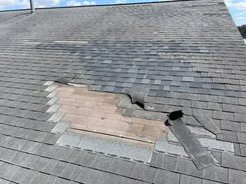 Missing shingles exposing the roof deck before repair